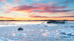 Sunset at the sea with ice and snow. Archipelago of Gothenburg, Sweden.